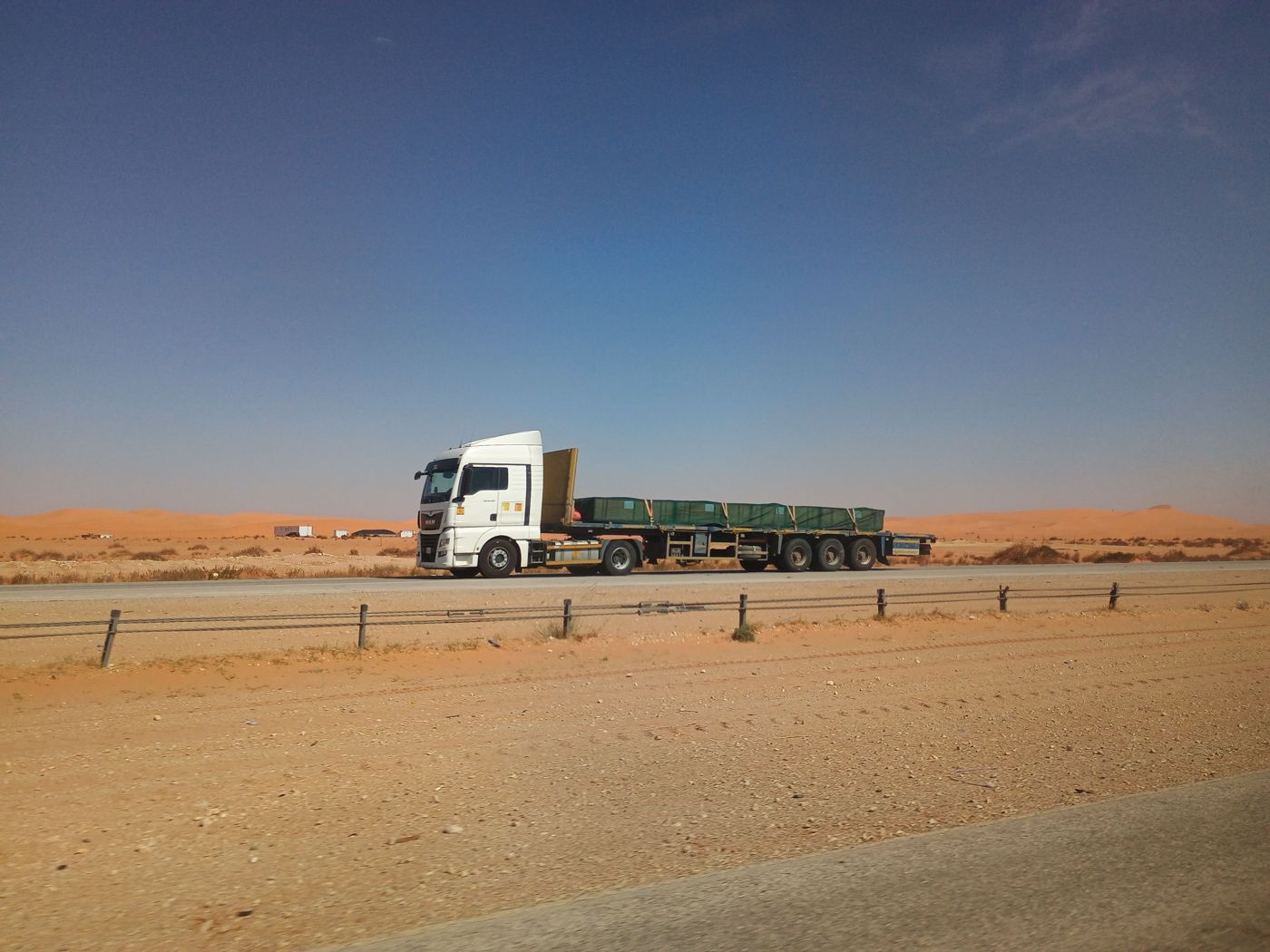 Camión con semirremolque cargado circulando por una ruta en una zona árida