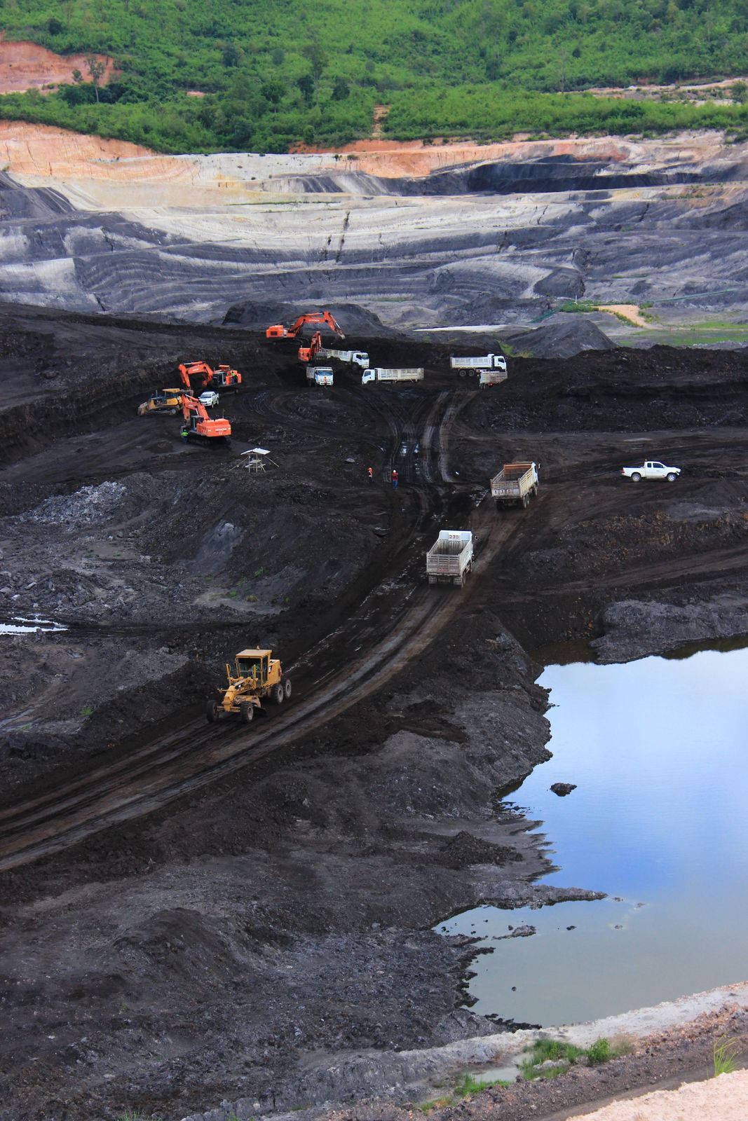 Excavadoras, camiones y motoniveladora trabajando en una mina a cielo abierto