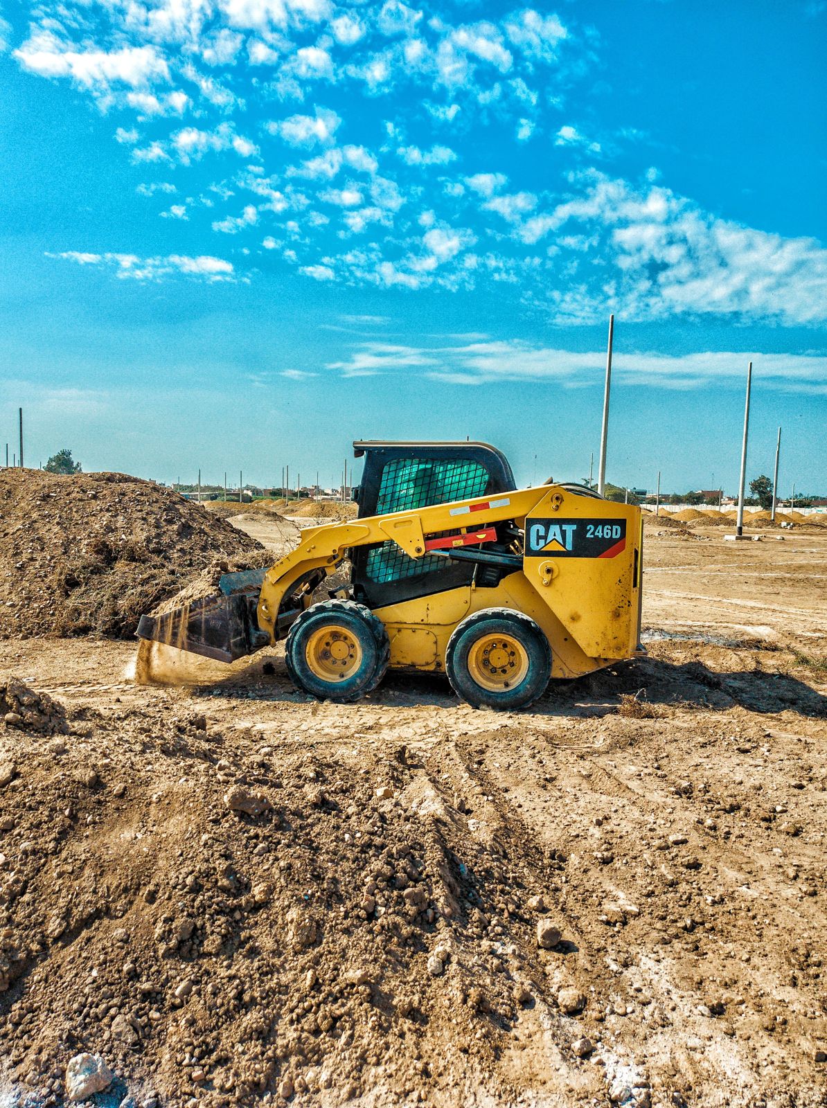 Minicargadora moviendo tierra en un terreno en preparación